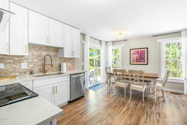 kitchen with light hardwood / wood-style floors, dishwasher, white cabinetry, sink, and backsplash