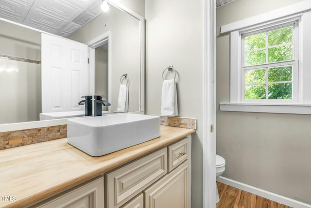 bathroom with vanity, toilet, and hardwood / wood-style floors