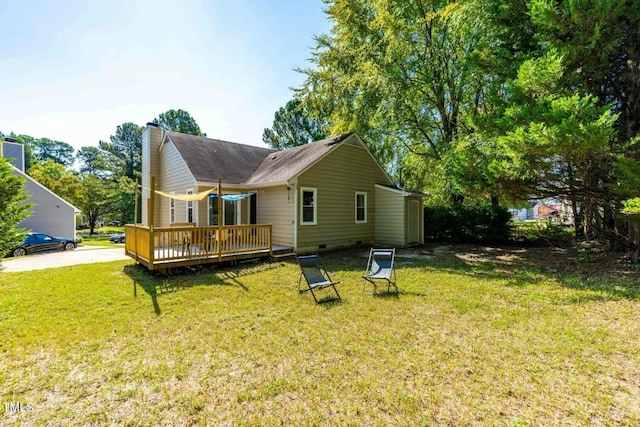 back of property with a wooden deck and a lawn