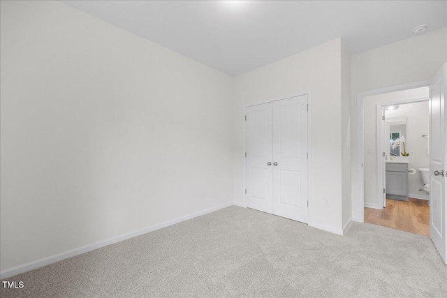 unfurnished bedroom with light carpet and a closet