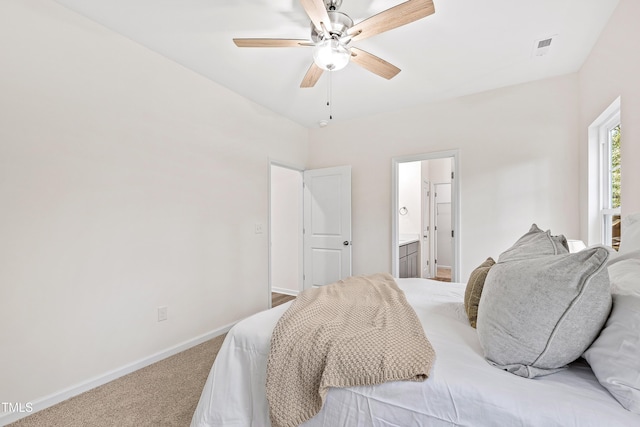 carpeted bedroom featuring ceiling fan and ensuite bath