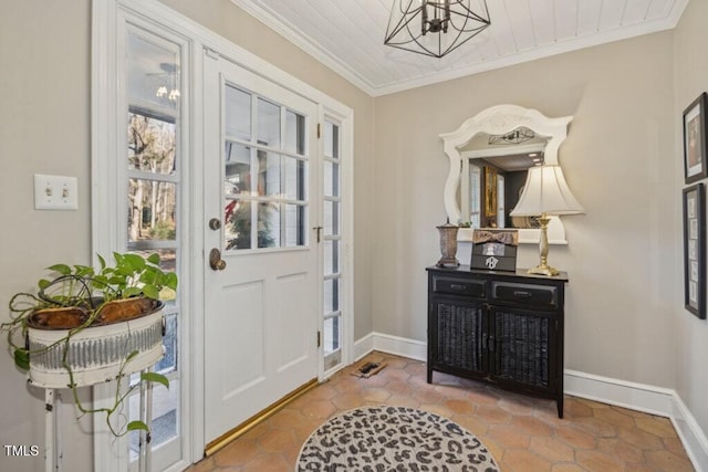 foyer with crown molding and a chandelier