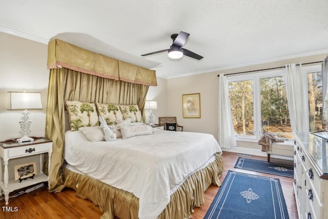 bedroom with ornamental molding, hardwood / wood-style floors, ceiling fan, and a textured ceiling