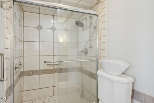 bathroom with toilet and a shower with shower door