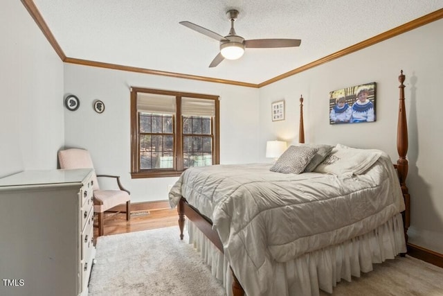 bedroom with ornamental molding, ceiling fan, and a textured ceiling