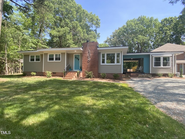 ranch-style home featuring a carport and a front lawn