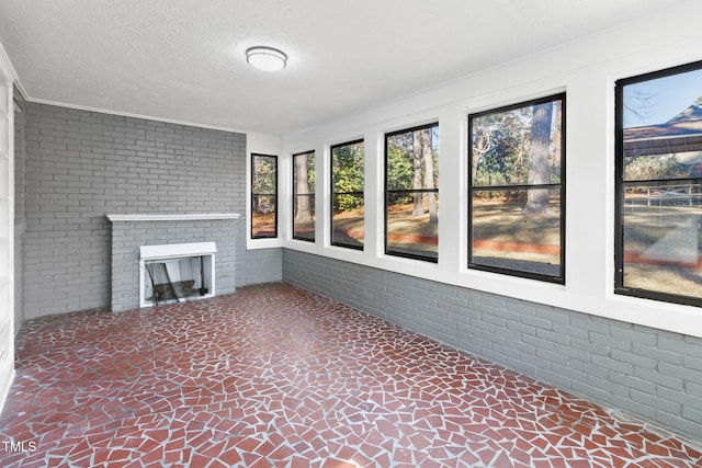 unfurnished sunroom featuring a fireplace