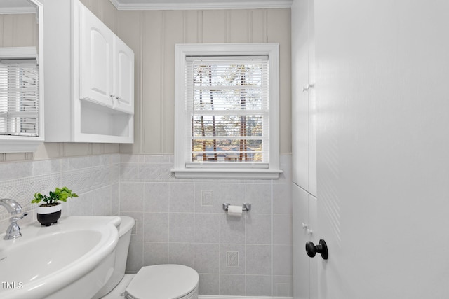 bathroom with sink, tile walls, and toilet