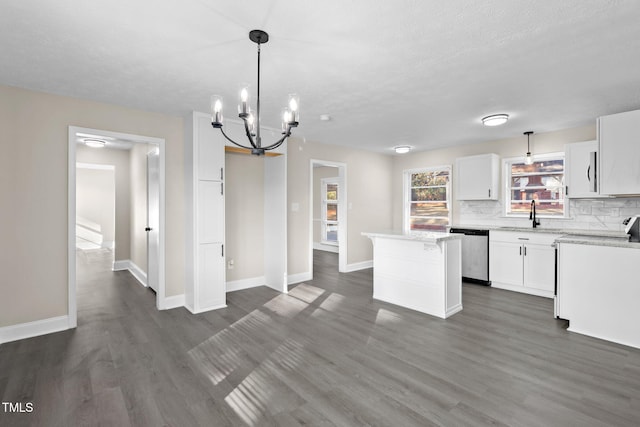 kitchen with hanging light fixtures, white cabinets, stainless steel dishwasher, and a kitchen island