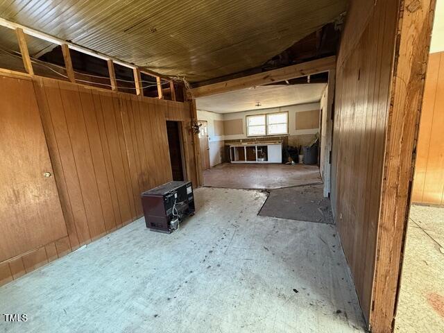 unfurnished living room with wood walls