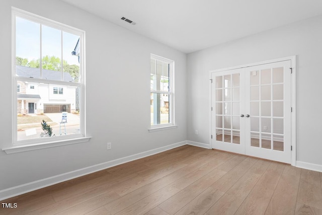 unfurnished room with baseboards, french doors, wood finished floors, and visible vents