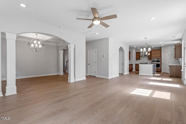 unfurnished living room featuring light wood-style flooring, arched walkways, and recessed lighting