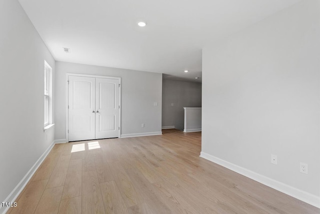 unfurnished room with recessed lighting, light wood-style flooring, and baseboards