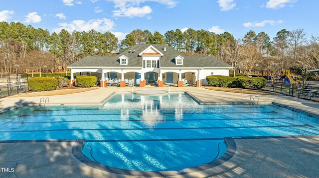 view of swimming pool featuring an outbuilding and a patio