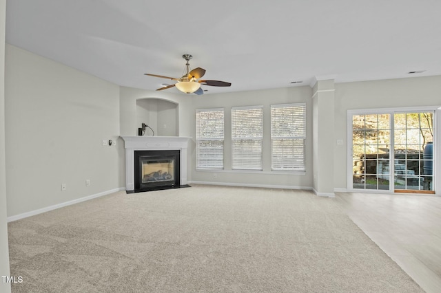 unfurnished living room featuring light carpet and ceiling fan