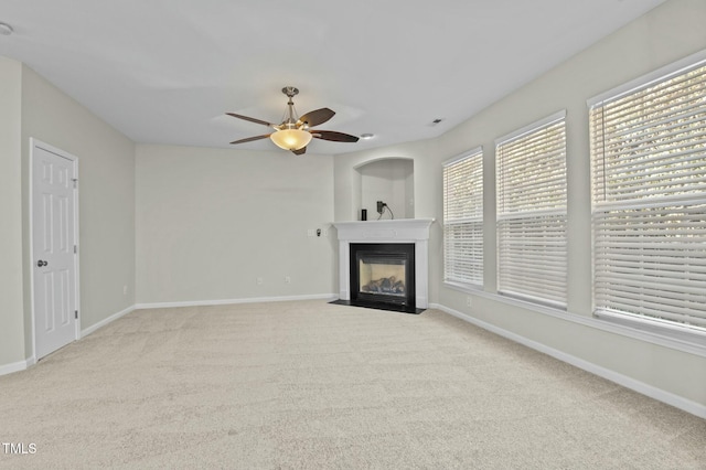 unfurnished living room featuring light carpet and ceiling fan