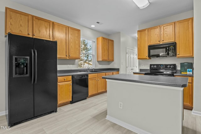 kitchen featuring sink, black appliances, and a center island