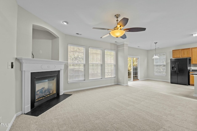 unfurnished living room featuring ceiling fan and carpet flooring