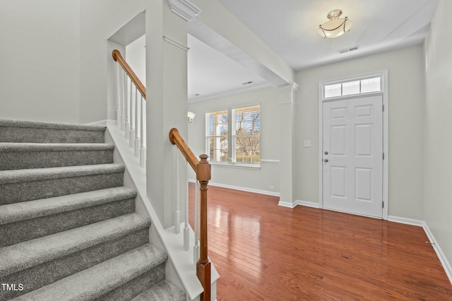 foyer entrance featuring hardwood / wood-style flooring, a healthy amount of sunlight, and crown molding