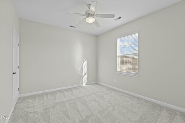 spare room with ceiling fan and light carpet