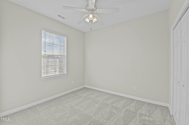 unfurnished bedroom featuring light carpet, a closet, and ceiling fan