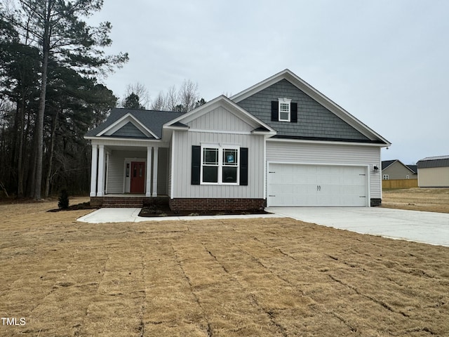 view of front of home featuring driveway, a porch, board and batten siding, and a front yard