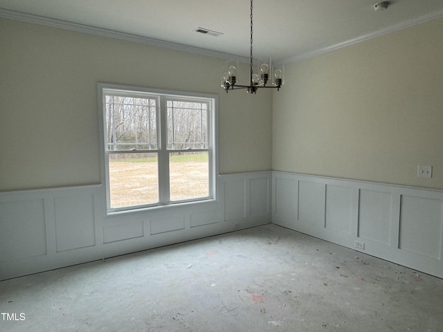 spare room featuring an inviting chandelier, plenty of natural light, and crown molding