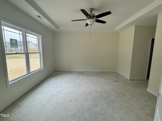 empty room with ceiling fan and a tray ceiling