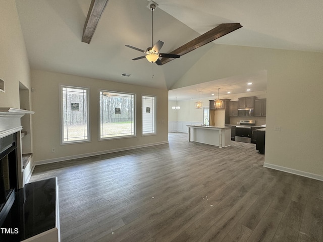 unfurnished living room featuring visible vents, dark wood finished floors, a ceiling fan, beamed ceiling, and a fireplace