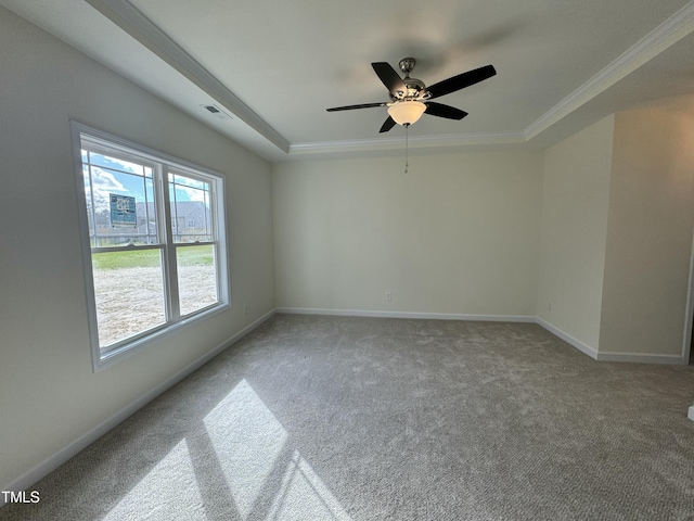 unfurnished room with visible vents, baseboards, a raised ceiling, light colored carpet, and crown molding