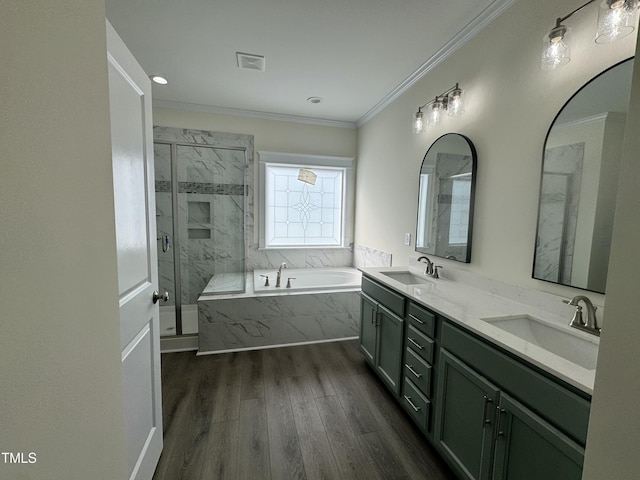 bathroom with wood finished floors, ornamental molding, a sink, and a marble finish shower