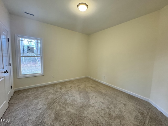 carpeted empty room featuring visible vents and baseboards