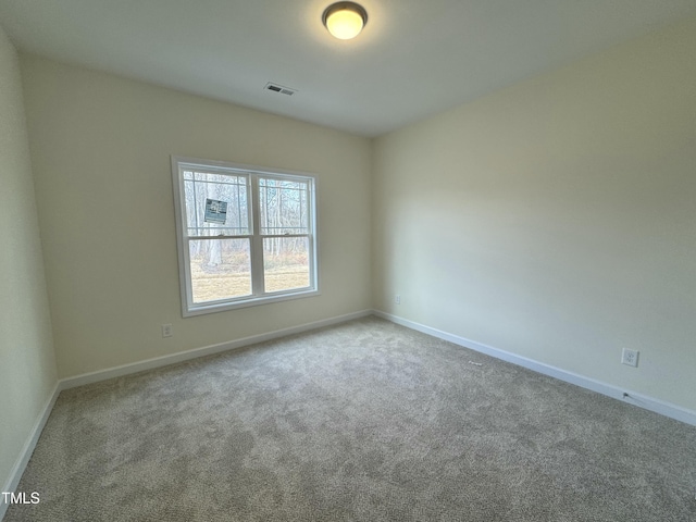 unfurnished room with carpet flooring, visible vents, and baseboards