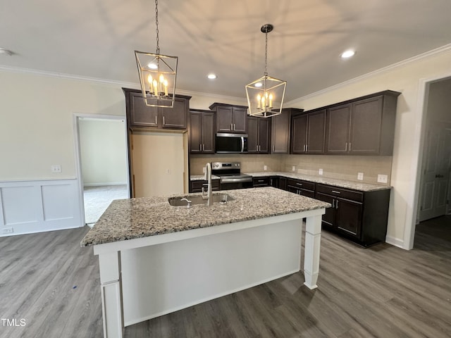 kitchen with dark brown cabinetry, decorative backsplash, ornamental molding, stainless steel appliances, and a sink