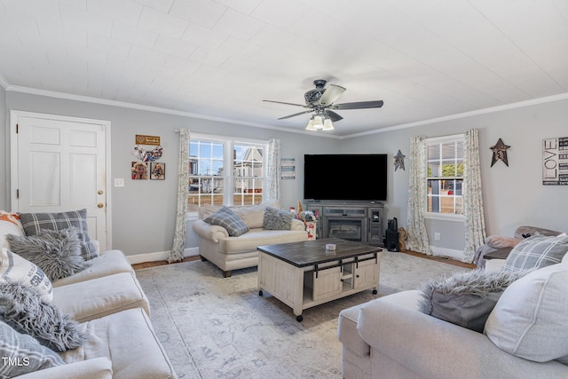 living room featuring ceiling fan, crown molding, and a fireplace