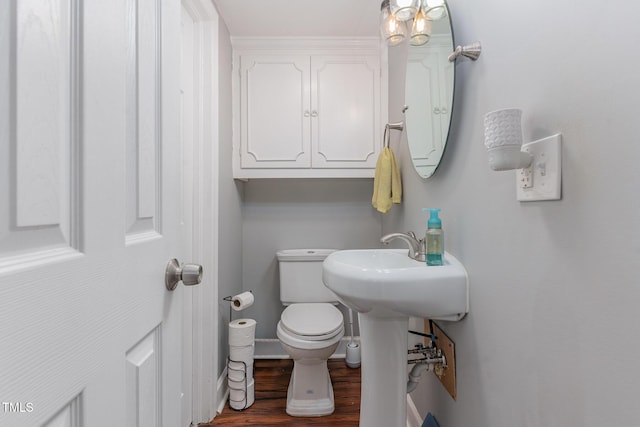 bathroom featuring wood-type flooring and toilet