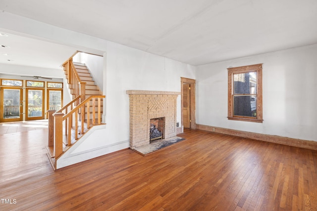 unfurnished living room featuring wood-type flooring, a fireplace, and a wealth of natural light