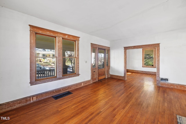 unfurnished room featuring hardwood / wood-style floors and plenty of natural light