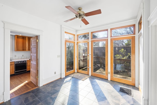 unfurnished sunroom with ceiling fan