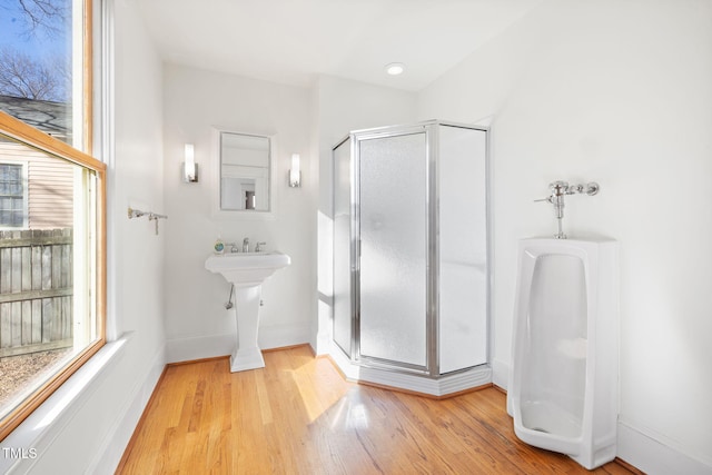 bathroom with hardwood / wood-style floors and an enclosed shower