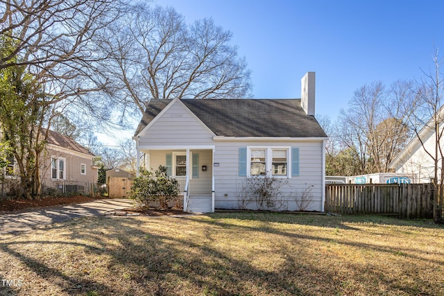 view of front of property featuring a chimney, fence, and a front lawn