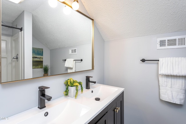 full bath with visible vents, a sink, and a textured ceiling