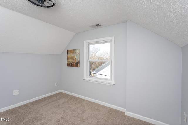 bonus room featuring a textured ceiling, carpet, visible vents, and baseboards