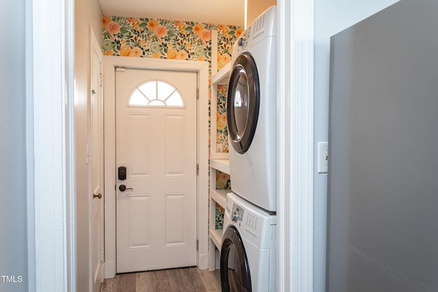 laundry area featuring stacked washer and dryer, laundry area, and light wood finished floors