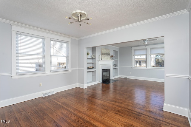 unfurnished living room featuring dark wood-style floors, visible vents, crown molding, and a glass covered fireplace