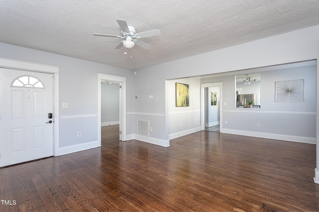 foyer entrance with ceiling fan, a textured ceiling, wood finished floors, visible vents, and baseboards