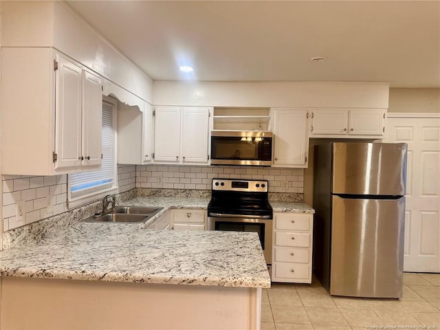 kitchen with stainless steel appliances, a sink, and white cabinetry