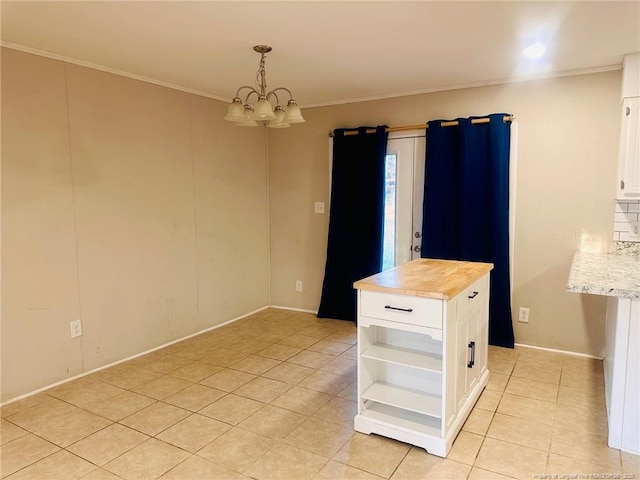 unfurnished dining area featuring an inviting chandelier, light tile patterned floors, and ornamental molding