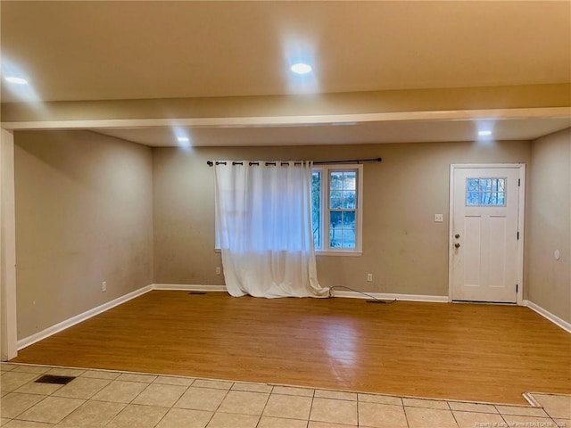 entryway with light wood finished floors, baseboards, and visible vents