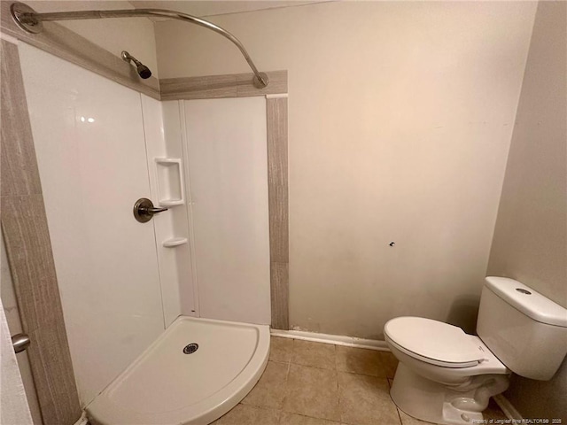 bathroom featuring a stall shower, tile patterned flooring, and toilet